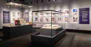 Display cases with books and panels from the Black Creativity Architecture Exhibit