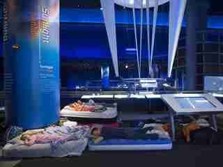 Snoozeum guests sleeping on air mattresses in the Science Storms exhibit.